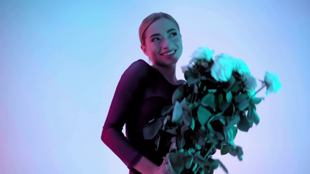Mladá balerína dostat kytice růží na modrém a růžovém pozadí - Záběry, video