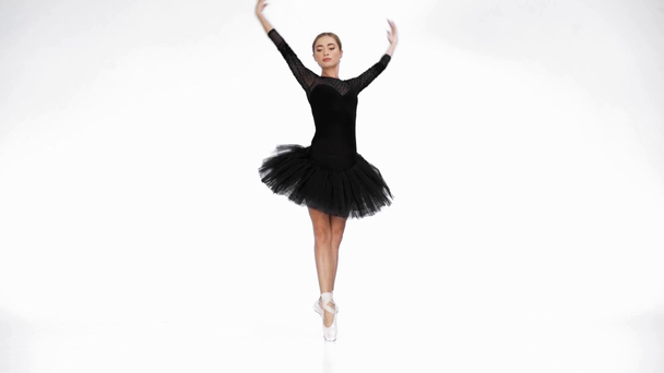 Elegant ballerina performing classical ballet moves on white background - Filmmaterial, Video