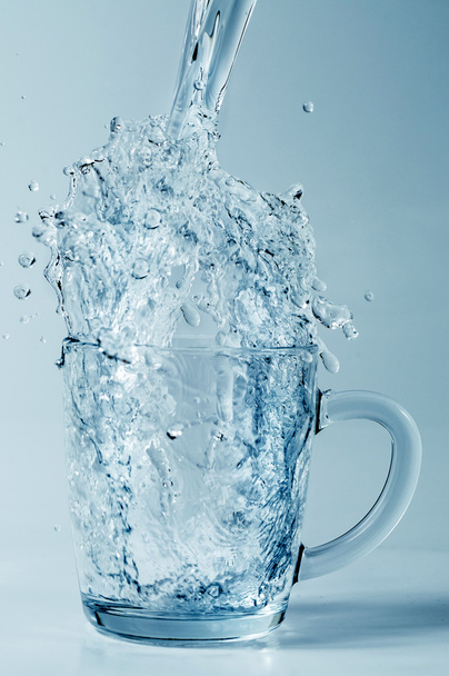 Verter agua en una taza de vidrio
 - Foto, imagen