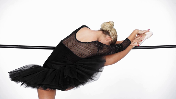 Elegante bailarina interpretando movimientos de ballet clásico en barra sobre fondo blanco - Imágenes, Vídeo