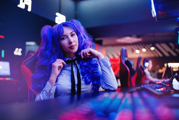Žena hráč sedací stůl, hraje online hry na počítači, neon barva - Fotografie, Obrázek