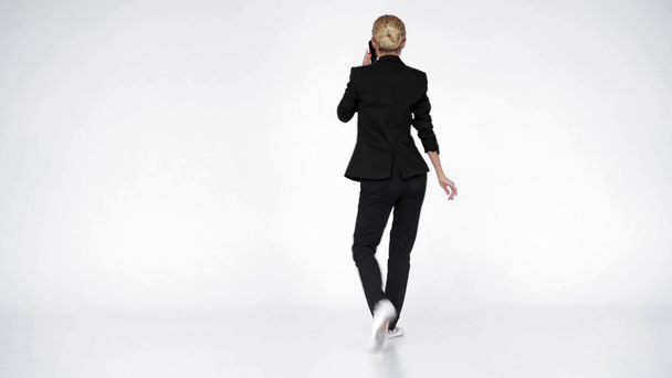 Elegante bailarina hablando en smartphone sobre fondo blanco - Imágenes, Vídeo