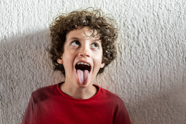 Funny guy with tongue out. Schoolboy grimace lifestyle portrait - Photo, Image