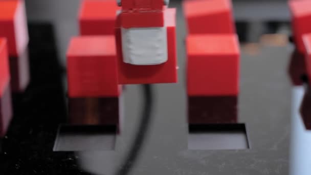 Robot kol manipülatörü robot sergisinde kırmızı oyuncak bloklarını hareket ettiriyor ve yerleştiriyor - Video, Çekim