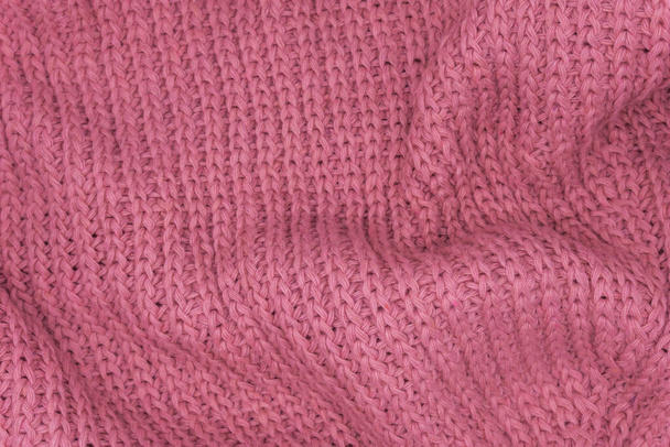 Struttura di un maglione lavorato a maglia rosa primo piano, lana lavorata a maglia rossa - Foto, immagini