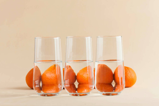 tangerine for glasses of water. Distorted image of water. Art concept, trending photo. Minimalism. Copy space. High quality photo - Fotó, kép