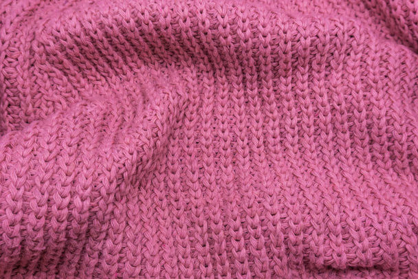 Textur eines rosafarbenen Strickpullovers in Nahaufnahme, rote Strickwolle - Foto, Bild