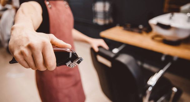 Barbershop braun retro für Männer, Barber hält Haarschneidemaschine in modernen - Foto, Bild