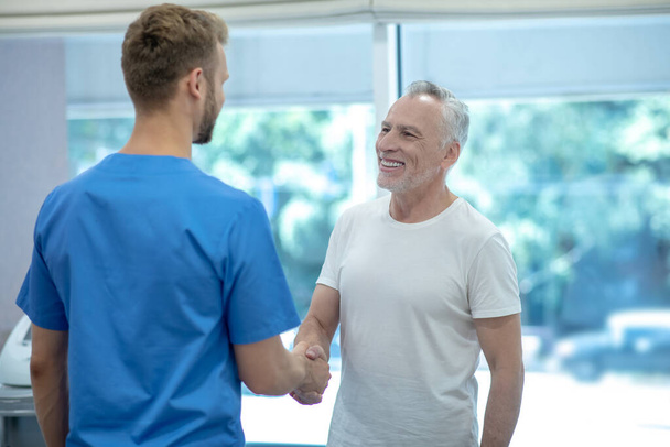 Two men shaking hands in medical office - 写真・画像
