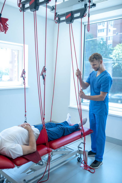 Male rehabilitation therapist preparing patient for training - Foto, Bild