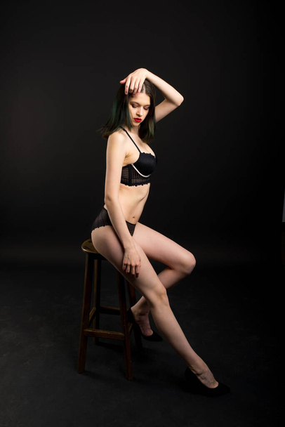 Linda morena modelo femenino posando, usando ropa interior negra en el estudio - Foto, imagen