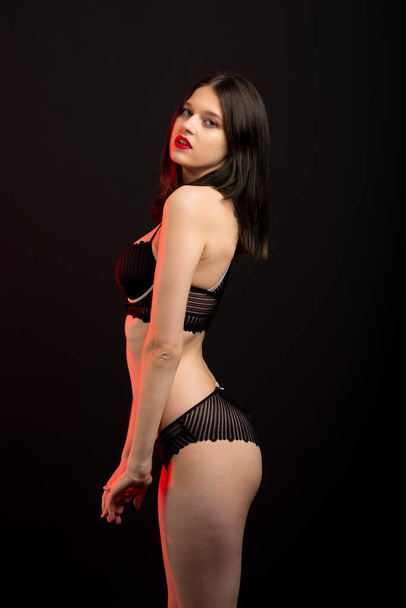 Cute brunette female model posing, wearing black underwear in studio - Photo, Image
