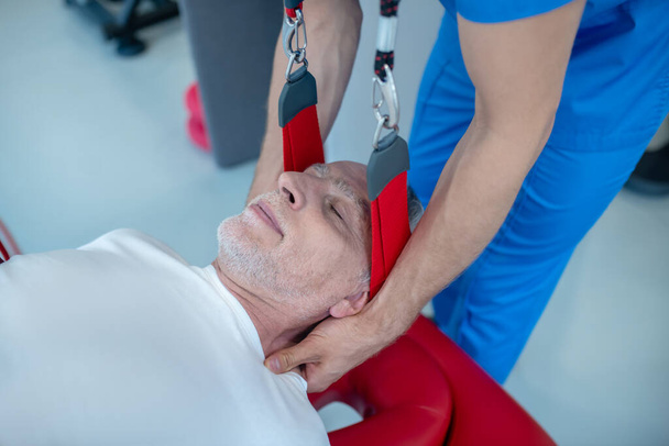 Calm elderly man and doctor giving neck massage - Fotoğraf, Görsel