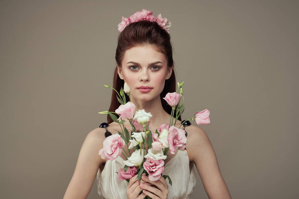 Ładna kobieta w białej sukience i bukiet kwiatów dekoracji kosmetyki styl życia - Zdjęcie, obraz