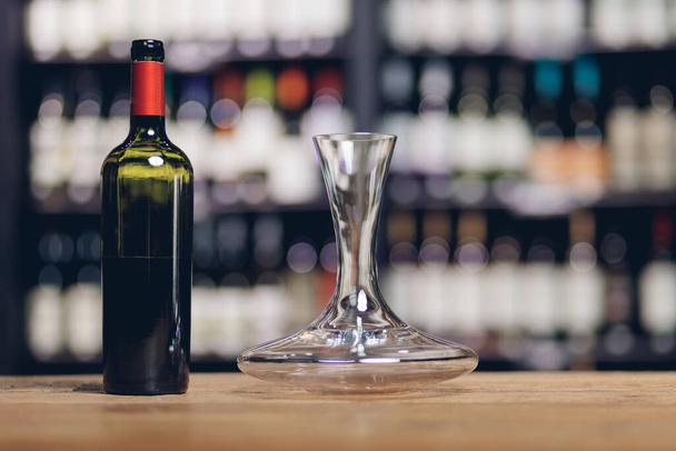 Γυαλί και καράφα κόκκινο κρασί σε ξύλινο μπαρ μετρητή στο εστιατόριο, αντίγραφο χώρου - Φωτογραφία, εικόνα