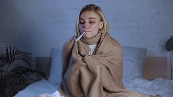 foco en rack de la mujer enferma sosteniendo termómetro digital en la boca cerca de la medicación - Metraje, vídeo