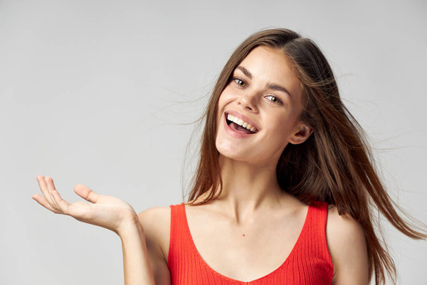 Щаслива жінка в червоній футболці показує руку в бік і сміється
  - Фото, зображення