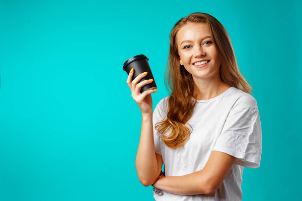 Jovem mulher atraente segurando uma xícara de bebida quente - Foto, Imagem