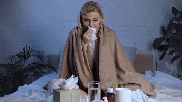 chora kobieta budzi rękę podczas rozmowy i kichania w pobliżu leków  - Materiał filmowy, wideo