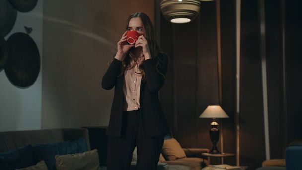 ビジネスの女性は夜のホテルのラウンジでお茶を飲む。従業員コーヒーを飲む - 写真・画像
