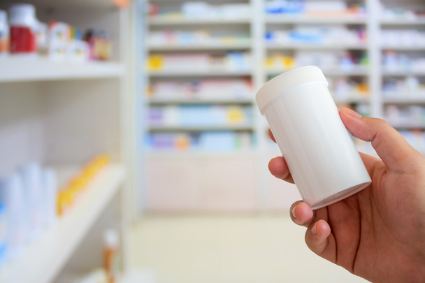 крупним планом жіночий фармацевт з пляшкою ліків в аптеці
 - Фото, зображення