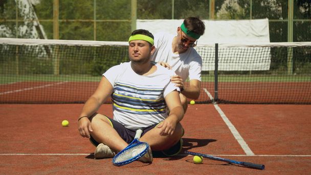 Entrenador masajeando hombros de tenista regordete - Foto, imagen