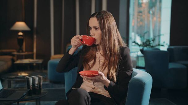 Business woman drinking tea in hotel lobby. Businesswoman drinking coffee - Fotó, kép