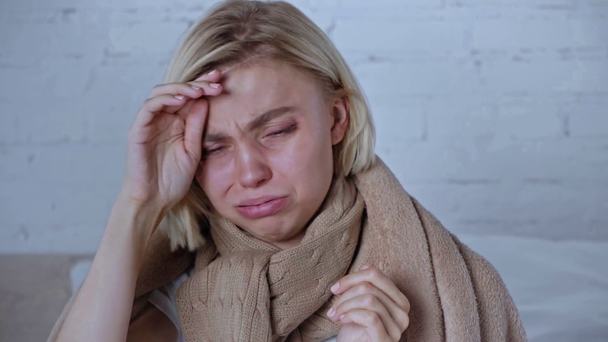 sick blonde woman wrapped in blanket sneezing and touching face - Filmagem, Vídeo