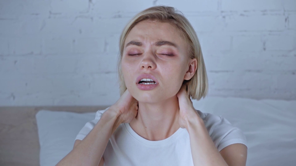 young blonde woman suffering from neck pain at home - Filmagem, Vídeo