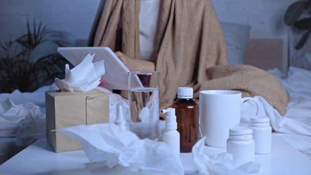 Selektiver Medikamentenfokus auf Tisch in der Nähe kranker Frau mit digitalem Tablet - Filmmaterial, Video