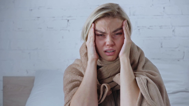 chora blondynka cierpiąca na ból głowy w domu - Materiał filmowy, wideo