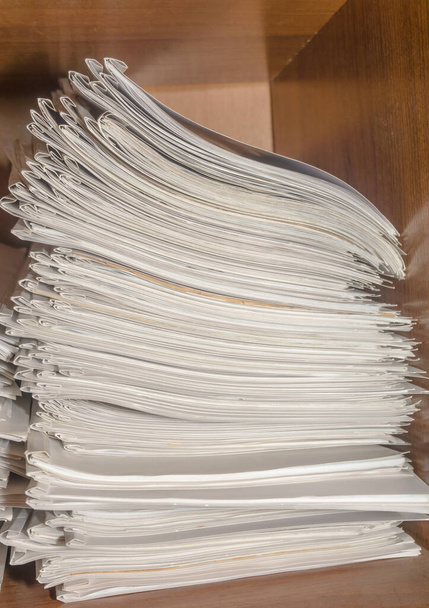 Старые бумажные документы, сложенные в архив. Документы на полках архивной комнаты. Полки в шкафу, заполненные файлами - Фото, изображение