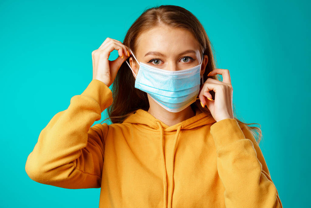 Young beautiful casual woman wearing protective medical mask - Foto, Imagen
