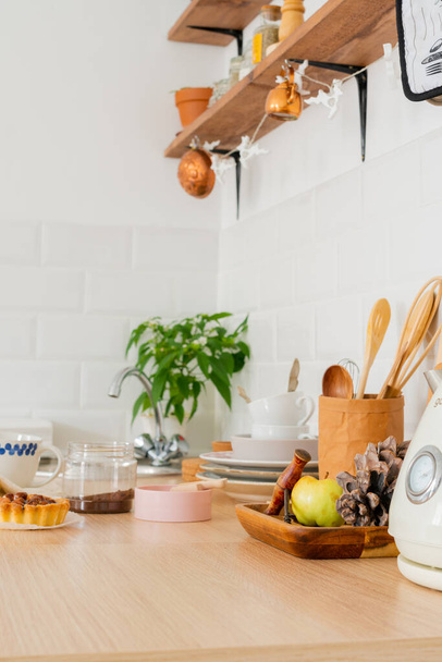 white kitchen interior. Scandinavian interior design in light colors with plants and accessories. kitchen details. Sunny day - 写真・画像