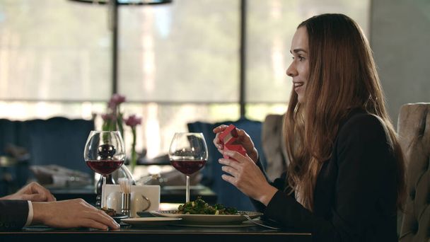 Ζευγάρι ερωτευμένο σε ρομαντικό ραντεβού στο εστιατόριο. Άντρας δίνει βέρα σε γυναίκα - Φωτογραφία, εικόνα