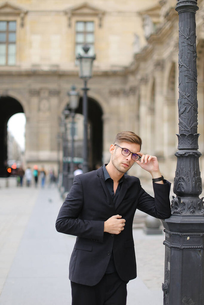 Jeune homme européen marchant à Paris et s'appuyant sur une lanterne, costume de sevrage. - Photo, image