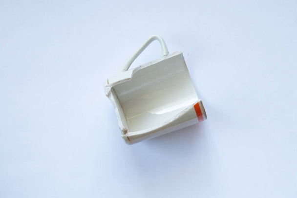weiße zerbrochene Tasse auf weißem Hintergrund in Nahaufnahme - Foto, Bild