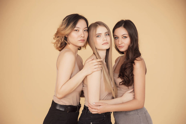 Ryhmä monirotuisia naisia seisoo halaus ja näköinen kamera. aasialainen, blondi, ruskeaverikkö - Valokuva, kuva