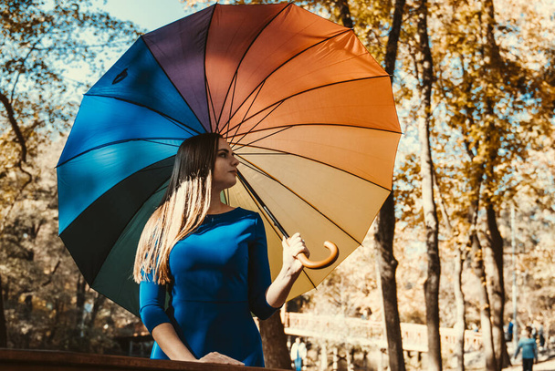 Νεαρή κοπέλα με πολύχρωμη ομπρέλα στο πάρκο του φθινοπώρου - Φωτογραφία, εικόνα