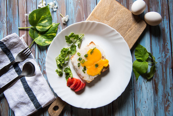 Gesundes Frühstücksprodukt pochiertes Ei auf Brot mit Gewürzen mit Blick von oben - Foto, Bild