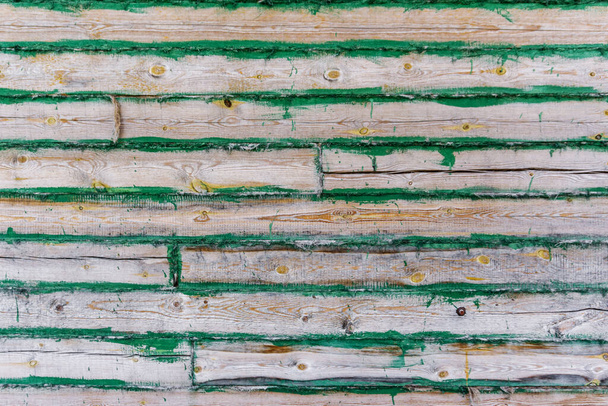 Wooden house made of wooden boards and panels with green paint background, wooden wall of building house, wooden fence of planks - Zdjęcie, obraz