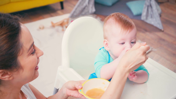brunette moeder voeden zuigeling zoon met baby voedsel  - Video