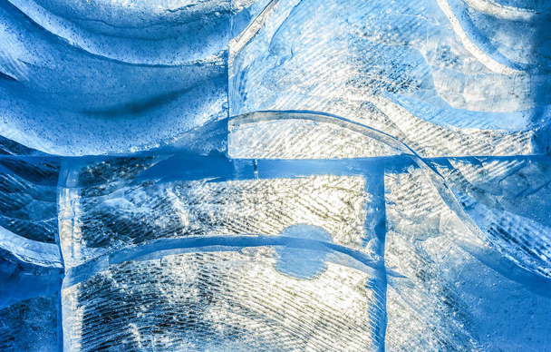 textura de gelo azul com um padrão e rachaduras fundo, gelo congelado pista fundo de inverno, textura da superfície do gelo, blocos de gelo iluminados pelo sol textura, água congelada - Foto, Imagem