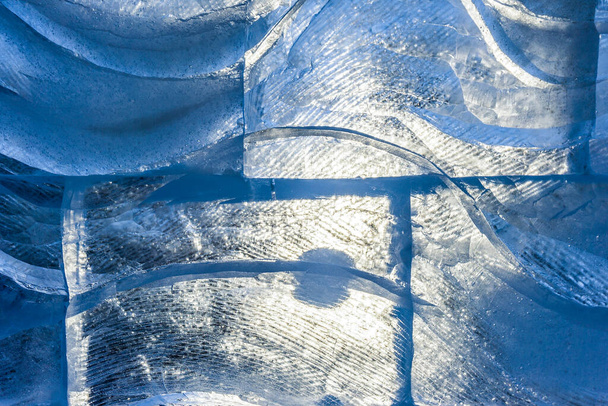 textura de gelo azul com um padrão e rachaduras fundo, gelo congelado pista fundo de inverno, textura da superfície do gelo, blocos de gelo iluminados pelo sol textura, água congelada - Foto, Imagem