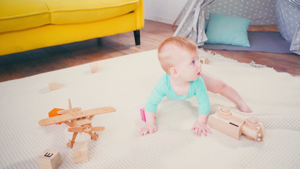 descalço bebê menino sentado no cobertor e brincando com brinquedos  - Filmagem, Vídeo
