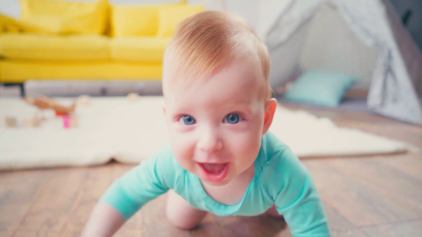 bebé niño mirando a la cámara mientras se arrastra en casa - Imágenes, Vídeo