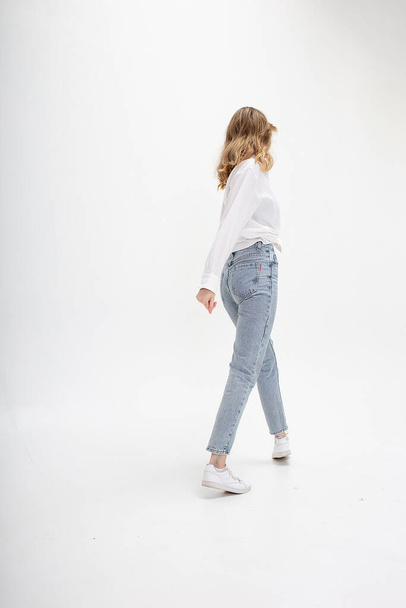 jovem caucasiano menina na camisa, jeans, isolado no fundo branco se afastando - Foto, Imagem