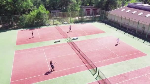 Menschen spielen im Sommer Tennis auf dem Platz - Filmmaterial, Video