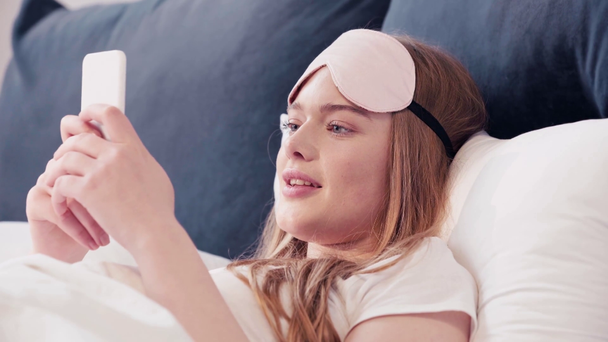 興奮した女性がベッドに横たわってテキストメッセージ - 映像、動画