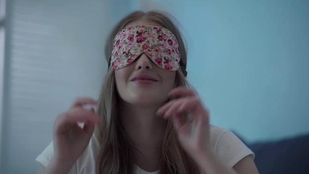 Młoda kobieta ciągnąca maskę snu na oczach - Materiał filmowy, wideo
